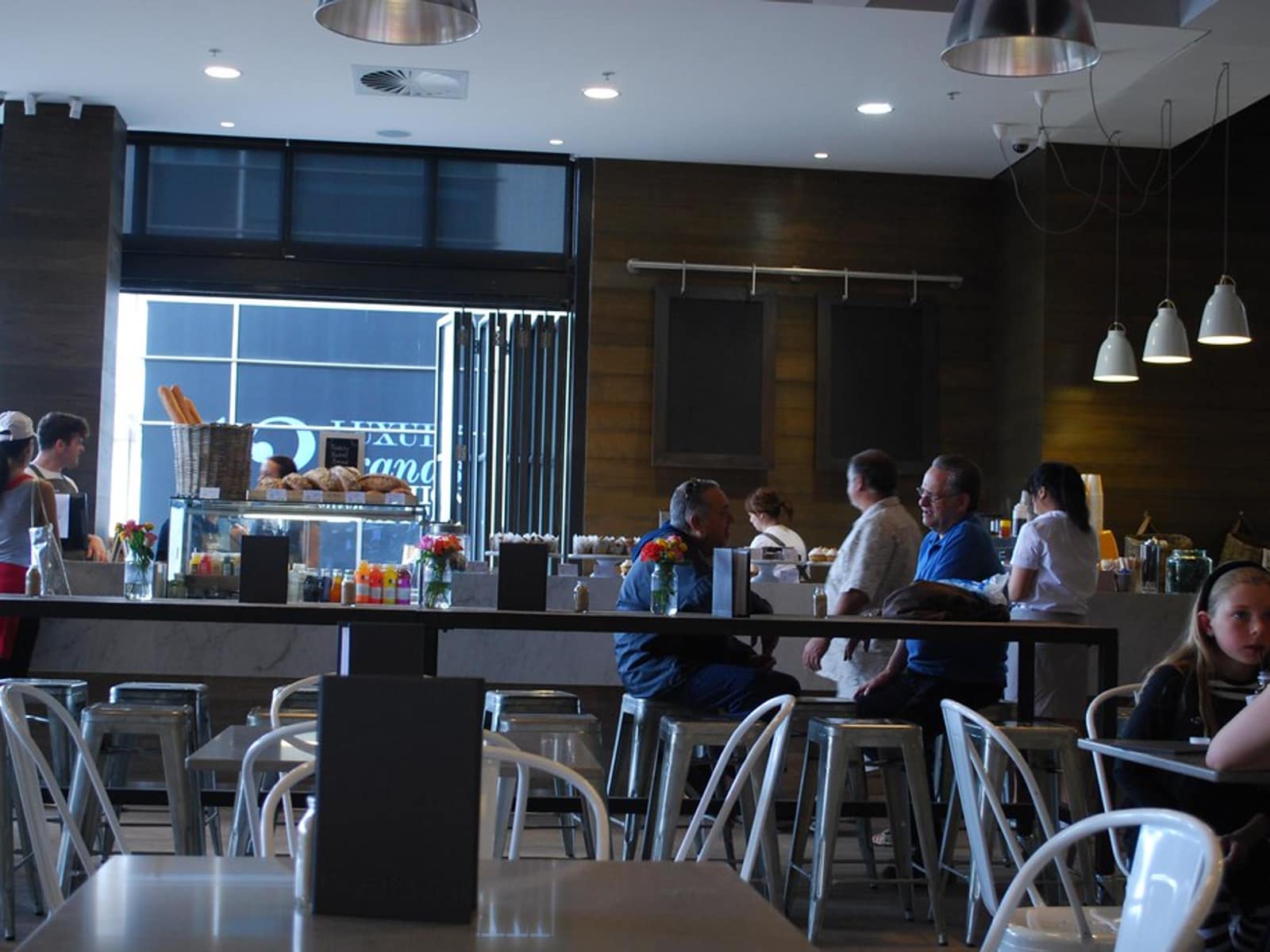 The interior of a café, tables set and counter behind.