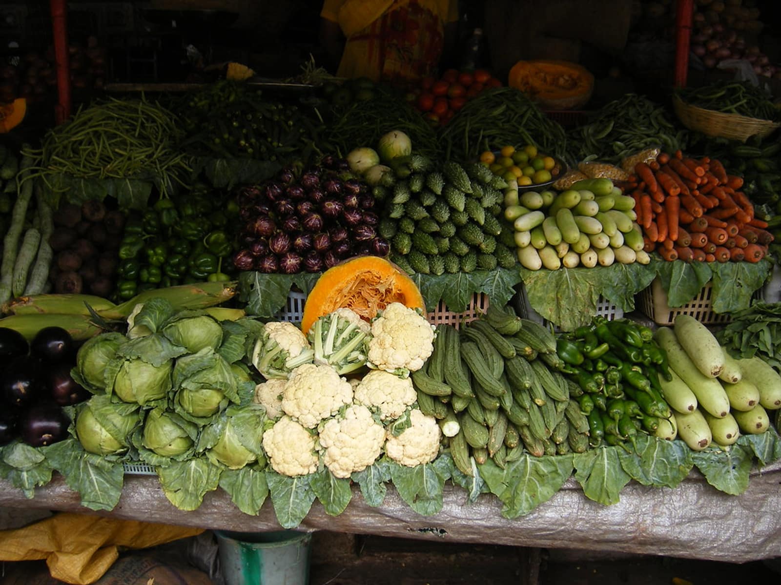 A greengrocer display banked with fresh vegetables.